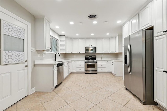 1221 Brockenbraugh Ct, Metairie, LA 70005 - kitchen featuring appliances with stainless steel finishes, light countertops, light tile patterned floors, recessed lighting, and white cabinets
