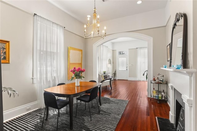 401 Pelican Ave, New Orleans, LA 70114 - dining area featuring arched walkways, wood finished floors, a chandelier, a fireplace with flush hearth, and recessed lighting