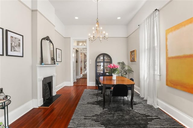 401 Pelican Ave, New Orleans, LA 70114 - dining area with a chandelier, wood finished floors, a fireplace with flush hearth, and recessed lighting