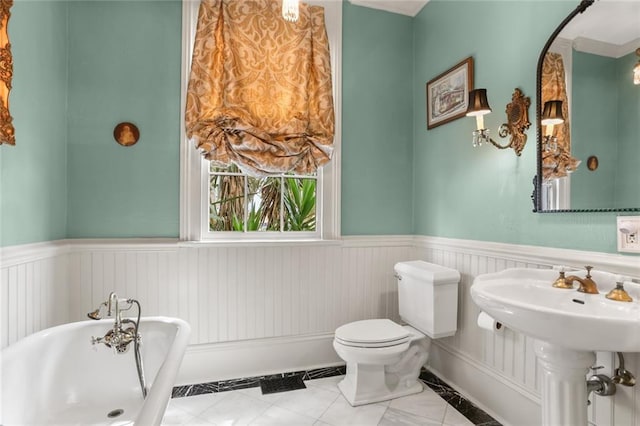 401 Pelican Ave, New Orleans, LA 70114 - bathroom with a freestanding tub, a wainscoted wall, and tile patterned floors