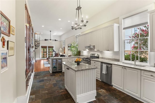 401 Pelican Ave, New Orleans, LA 70114 - kitchen with appliances with stainless steel finishes, stone tile floors, wine cooler, recessed lighting, and a kitchen island