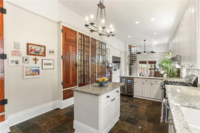 401 Pelican Ave, New Orleans, LA 70114 - kitchen with stainless steel gas stove, beverage cooler, stone tile flooring, a chandelier, and recessed lighting