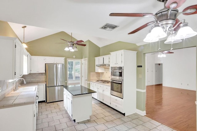 891 Cross Gates Blvd, Slidell, LA 70461 - kitchen with appliances with stainless steel finishes, a ceiling fan, backsplash, white cabinetry, and a kitchen island