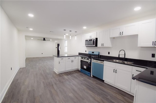 4235 Alfred St, New Orleans, LA 70122 - kitchen with appliances with stainless steel finishes, a peninsula, dark countertops, white cabinets, and wood finished floors