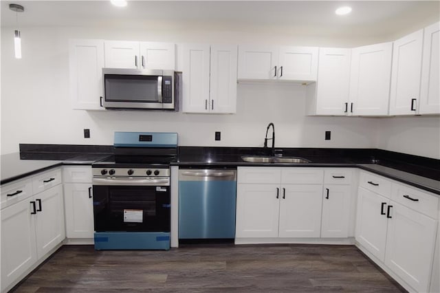 4235 Alfred St, New Orleans, LA 70122 - kitchen with appliances with stainless steel finishes, white cabinetry, recessed lighting, dark countertops, and dark wood finished floors