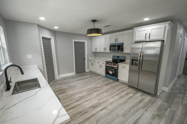 206 Fairfax Pl, New Orleans, LA 70131 - kitchen featuring appliances with stainless steel finishes, light stone countertops, recessed lighting, light wood-type flooring, and white cabinets