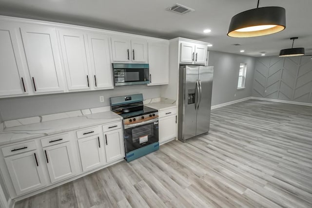 206 Fairfax Pl, New Orleans, LA 70131 - kitchen with appliances with stainless steel finishes, light wood-style floors, white cabinetry, decorative light fixtures, and light stone countertops