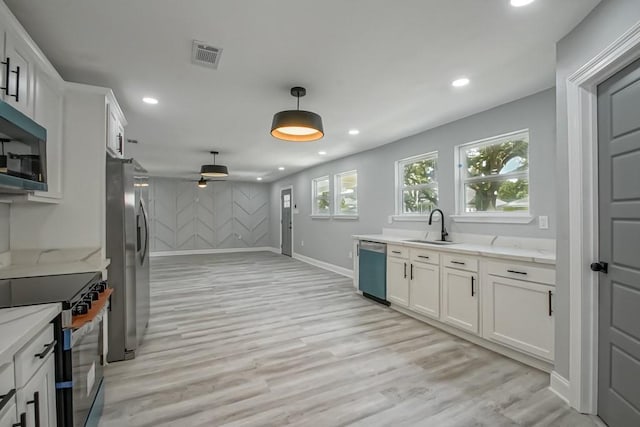 206 Fairfax Pl, New Orleans, LA 70131 - kitchen with appliances with stainless steel finishes, a ceiling fan, recessed lighting, white cabinets, and light wood finished floors