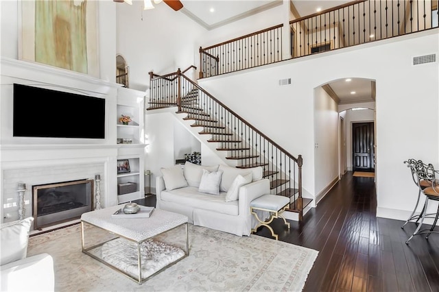 1456 Cherokee Ave, Metairie, LA 70005 - living area featuring a towering ceiling, a glass covered fireplace, ornamental molding, arched walkways, and a ceiling fan