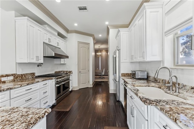 1456 Cherokee Ave, Metairie, LA 70005 - kitchen with premium appliances, under cabinet range hood, white cabinets, light stone countertops, and recessed lighting