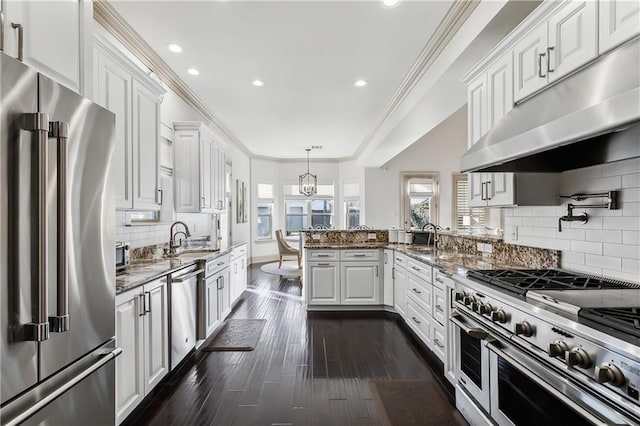 1456 Cherokee Ave, Metairie, LA 70005 - kitchen with premium appliances, under cabinet range hood, white cabinetry, a peninsula, and ornamental molding