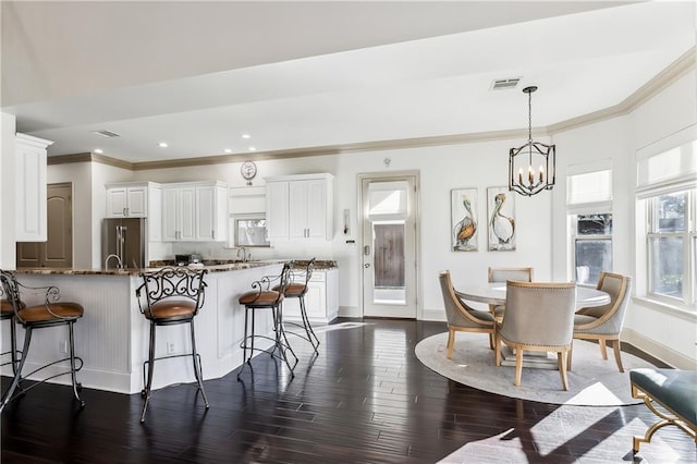 1456 Cherokee Ave, Metairie, LA 70005 - kitchen featuring high end refrigerator, a breakfast bar area, dark wood-type flooring, crown molding, and a peninsula