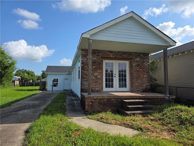2365 N Tonti St, New Orleans, LA 70117 - view of front of property featuring french doors, brick siding, and concrete driveway