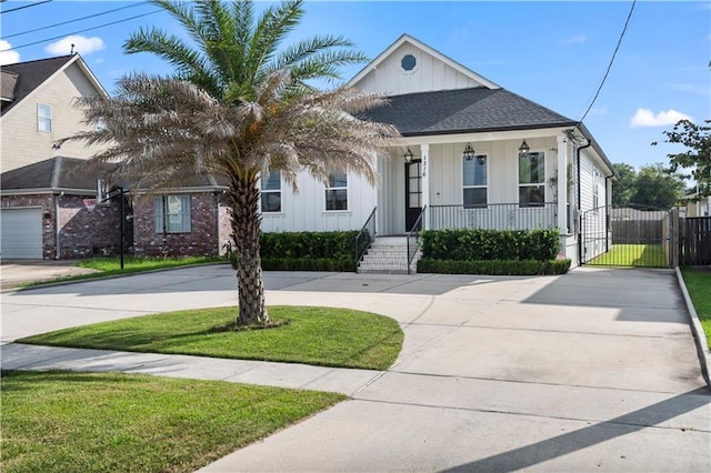 1316 Hickory Ave, Harahan, LA 70123 - view of front of house featuring board and batten siding, a porch, curved driveway, and a gate