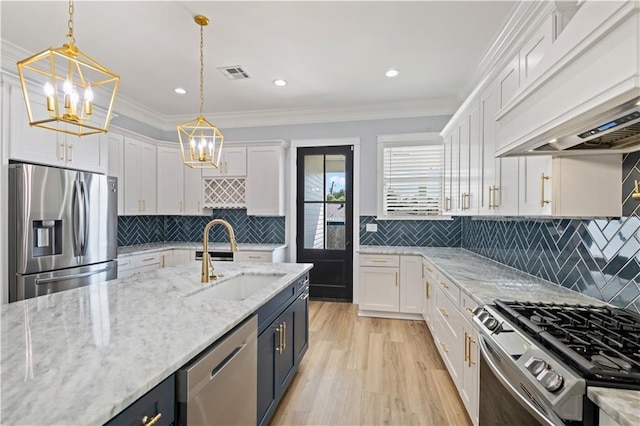 1316 Hickory Ave, Harahan, LA 70123 - kitchen with appliances with stainless steel finishes, a chandelier, premium range hood, white cabinets, and light wood finished floors