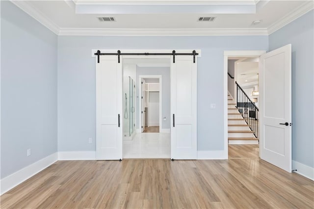 1316 Hickory Ave, Harahan, LA 70123 - empty room featuring a barn door, crown molding, light wood-style flooring, and stairs