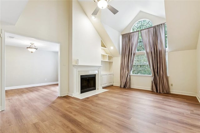 3523 Audubon Trce Unit 3523, Jefferson, LA 70121 - unfurnished living room with high vaulted ceiling, a ceiling fan, a fireplace, light wood-style flooring, and built in shelves
