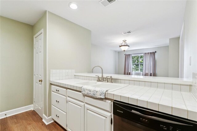 3523 Audubon Trce Unit 3523, Jefferson, LA 70121 - kitchen featuring black dishwasher, tile counters, light wood-type flooring, a peninsula, and recessed lighting