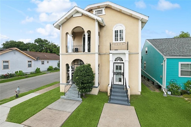 1631 S Salcedo St, New Orleans, LA 70125 - view of front of home featuring a balcony, a front yard, and stucco siding