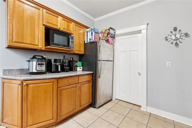 1631 S Salcedo St, New Orleans, LA 70125 - kitchen featuring black microwave, freestanding refrigerator, brown cabinets, light tile patterned floors, and ornamental molding