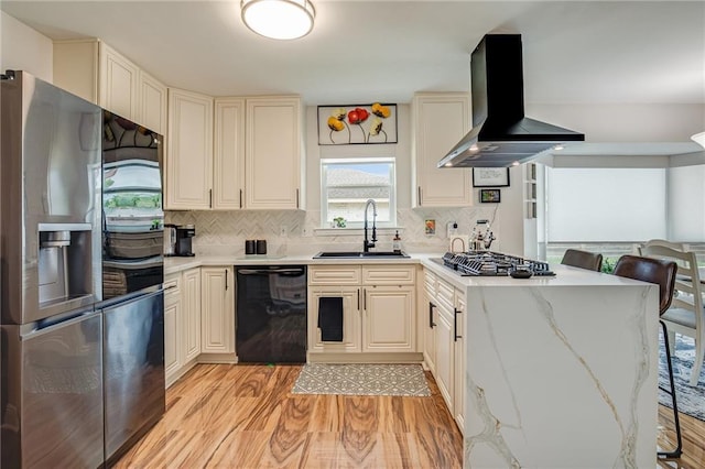 42 Melrose Dr, Destrehan, LA 70047 - kitchen with appliances with stainless steel finishes, wall chimney exhaust hood, light wood-style floors, and decorative backsplash