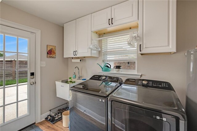 42 Melrose Dr, Destrehan, LA 70047 - laundry area with washer and clothes dryer, water heater, wood finished floors, and cabinet space