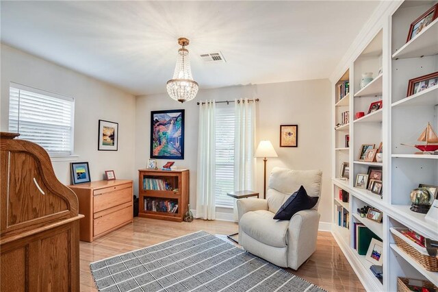 42 Melrose Dr, Destrehan, LA 70047 - sitting room with a chandelier, light wood finished floors, and built in shelves