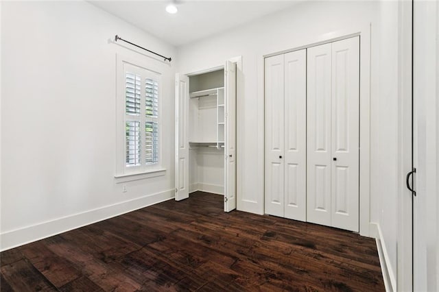 904 W 16th Ave, Covington, LA 70433 - unfurnished bedroom with two closets and dark wood finished floors
