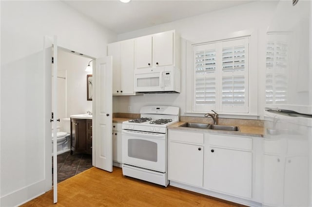 904 W 16th Ave, Covington, LA 70433 - kitchen featuring white appliances, white cabinets, light countertops, and light wood-style flooring
