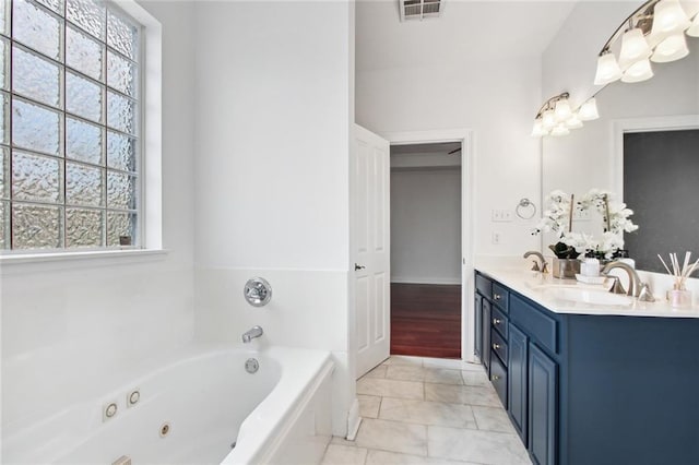 5910 Milne Blvd, New Orleans, LA 70124 - full bath with double vanity, a jetted tub, and marble look tile flooring