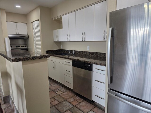 4829 Wabash St Unit 307, Metairie, LA 70001 - kitchen featuring appliances with stainless steel finishes, under cabinet range hood, dark stone finish flooring, white cabinetry, and recessed lighting