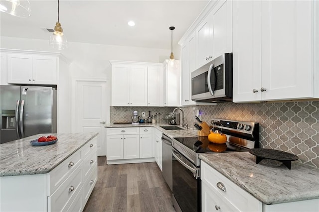 19480 N 3rd St, Covington, LA 70433 - kitchen featuring stainless steel appliances, wood finished floors, white cabinets, decorative backsplash, and light stone counters