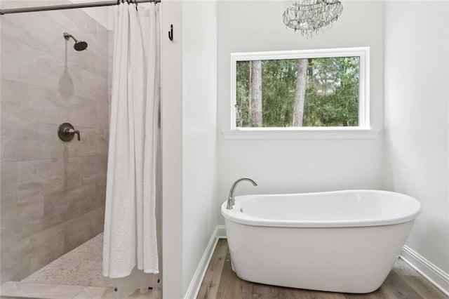 19480 N 3rd St, Covington, LA 70433 - bathroom with wood finished floors, a freestanding bath, a tile shower, and a chandelier