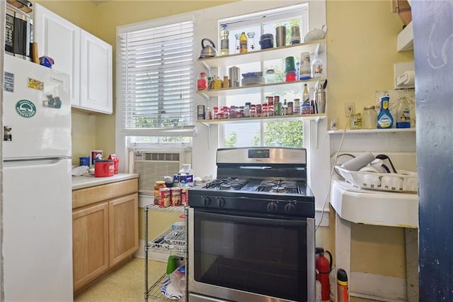 113335 Fern St, New Orleans, LA 70118 - kitchen with freestanding refrigerator, stainless steel gas stove, healthy amount of natural light, and light countertops