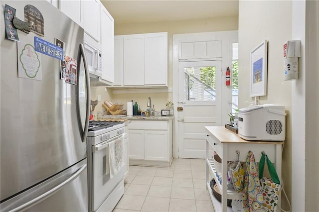113335 Fern St, New Orleans, LA 70118 - kitchen with white appliances, light countertops, white cabinets, and light tile patterned flooring