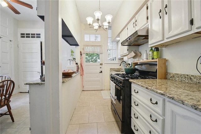 113335 Fern St, New Orleans, LA 70118 - kitchen with black gas range oven, under cabinet range hood, a chandelier, white microwave, and light tile patterned floors
