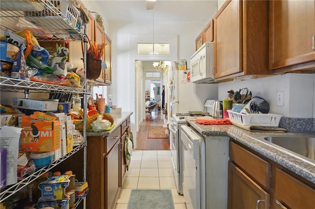 113335 Fern St, New Orleans, LA 70118 - kitchen featuring white microwave, gas range oven, brown cabinetry, and light tile patterned floors