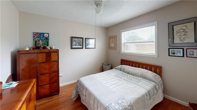 3229 Hero Dr, Gretna, LA 70053 - bedroom featuring wood finished floors, a textured ceiling, and a ceiling fan