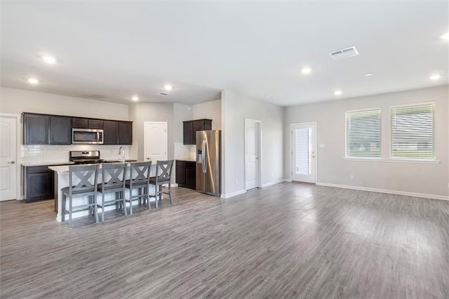 7542 1ST Lake Dr, Slidell, LA 70461 - kitchen with stainless steel appliances, light wood-style floors, open floor plan, recessed lighting, and a breakfast bar