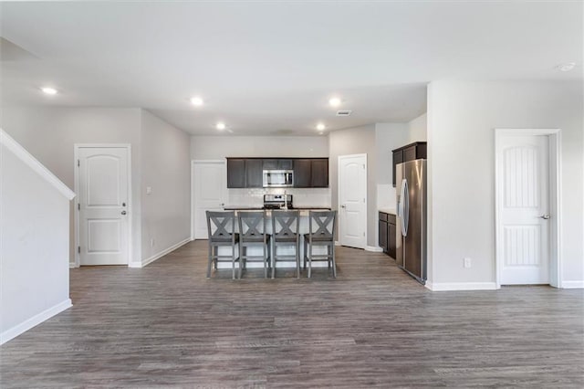 7542 1ST Lake Dr, Slidell, LA 70461 - kitchen featuring stainless steel appliances, open floor plan, a center island with sink, dark wood finished floors, and dark brown cabinets