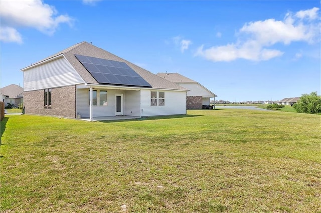 7542 1ST Lake Dr, Slidell, LA 70461 - back of property featuring roof mounted solar panels, a patio, brick siding, and a yard