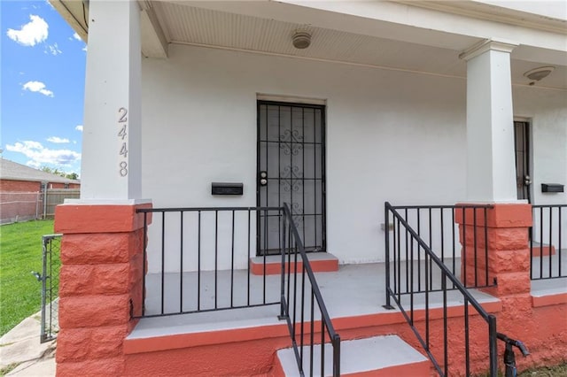 2446 N Rocheblave St, New Orleans, LA 70117 - view of exterior entry with a porch and stucco siding