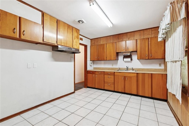 508 Arnold Ave, River Ridge, LA 70123 - kitchen with under cabinet range hood, light countertops, and brown cabinetry