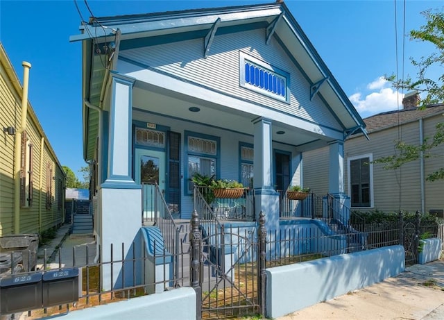 623-25 Louisa St, New Orleans, LA 70117 - view of front facade featuring covered porch, stairway, and a fenced front yard