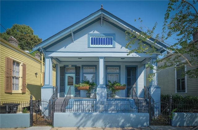 623-25 Louisa St, New Orleans, LA 70117 - view of front of property featuring covered porch, a fenced front yard, and a gate