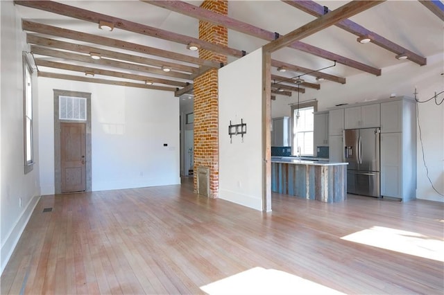 623-25 Louisa St, New Orleans, LA 70117 - unfurnished living room with beamed ceiling and light wood finished floors