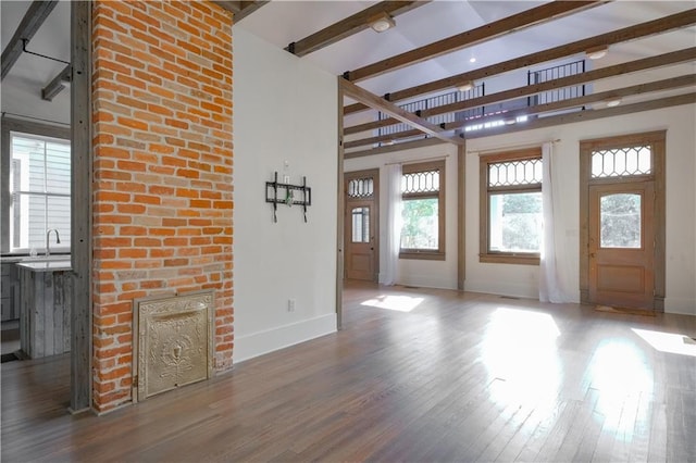 623-25 Louisa St, New Orleans, LA 70117 - unfurnished living room with healthy amount of natural light, wood finished floors, high vaulted ceiling, beamed ceiling, and a fireplace