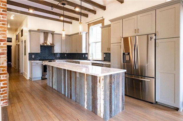 623-25 Louisa St, New Orleans, LA 70117 - kitchen featuring stainless steel appliances, a center island, wall chimney range hood, tasteful backsplash, and light wood finished floors