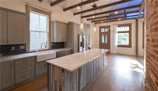 623-25 Louisa St, New Orleans, LA 70117 - kitchen with gray cabinetry, stainless steel appliances, wood finished floors, tasteful backsplash, and beam ceiling