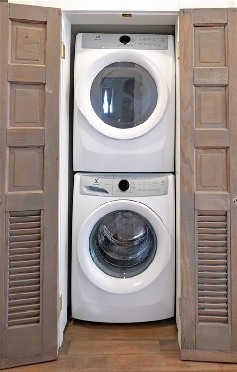 623-25 Louisa St, New Orleans, LA 70117 - washroom featuring stacked washer / dryer and light wood-type flooring